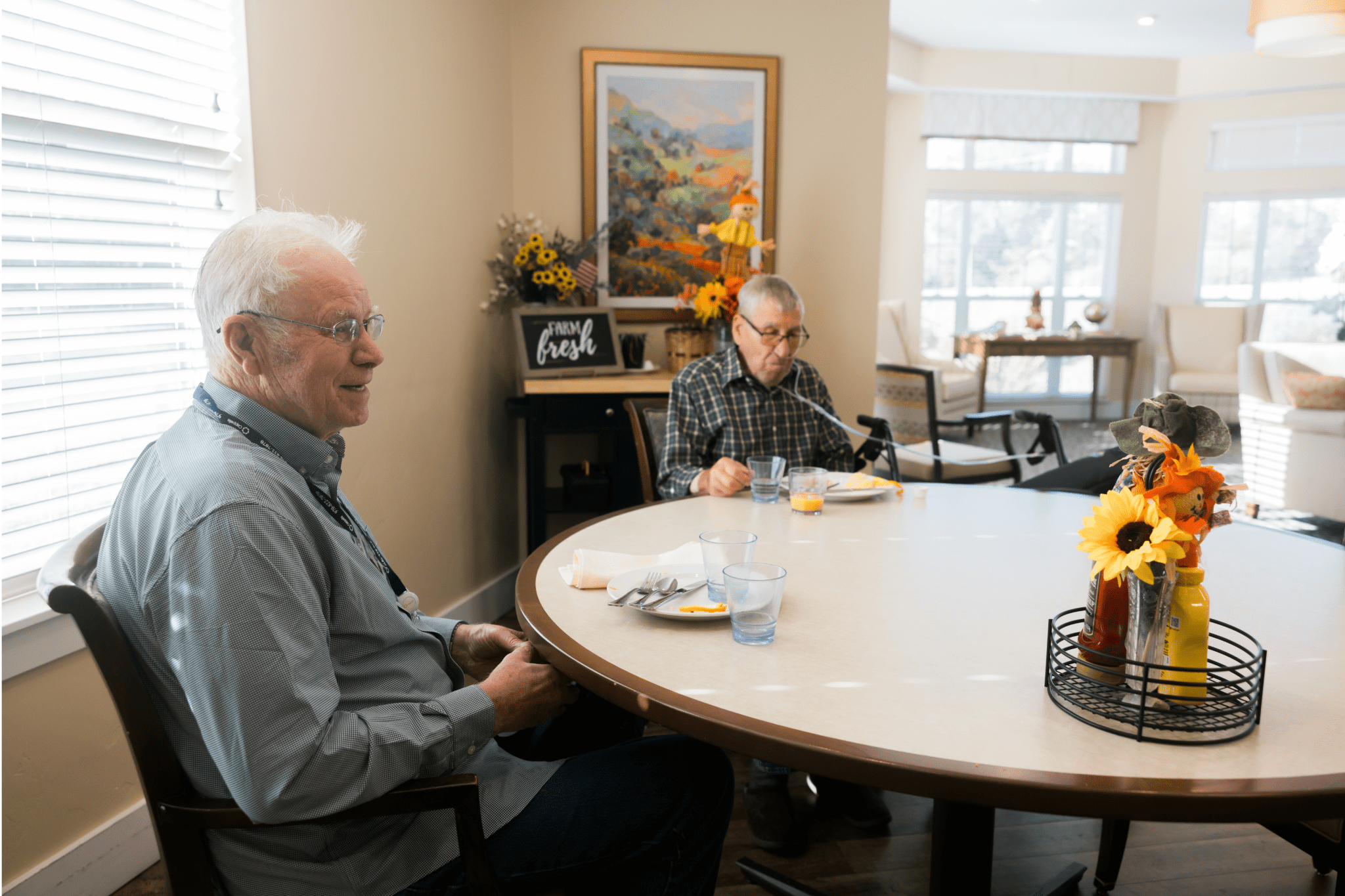 residents sitting at community dining table large landscape